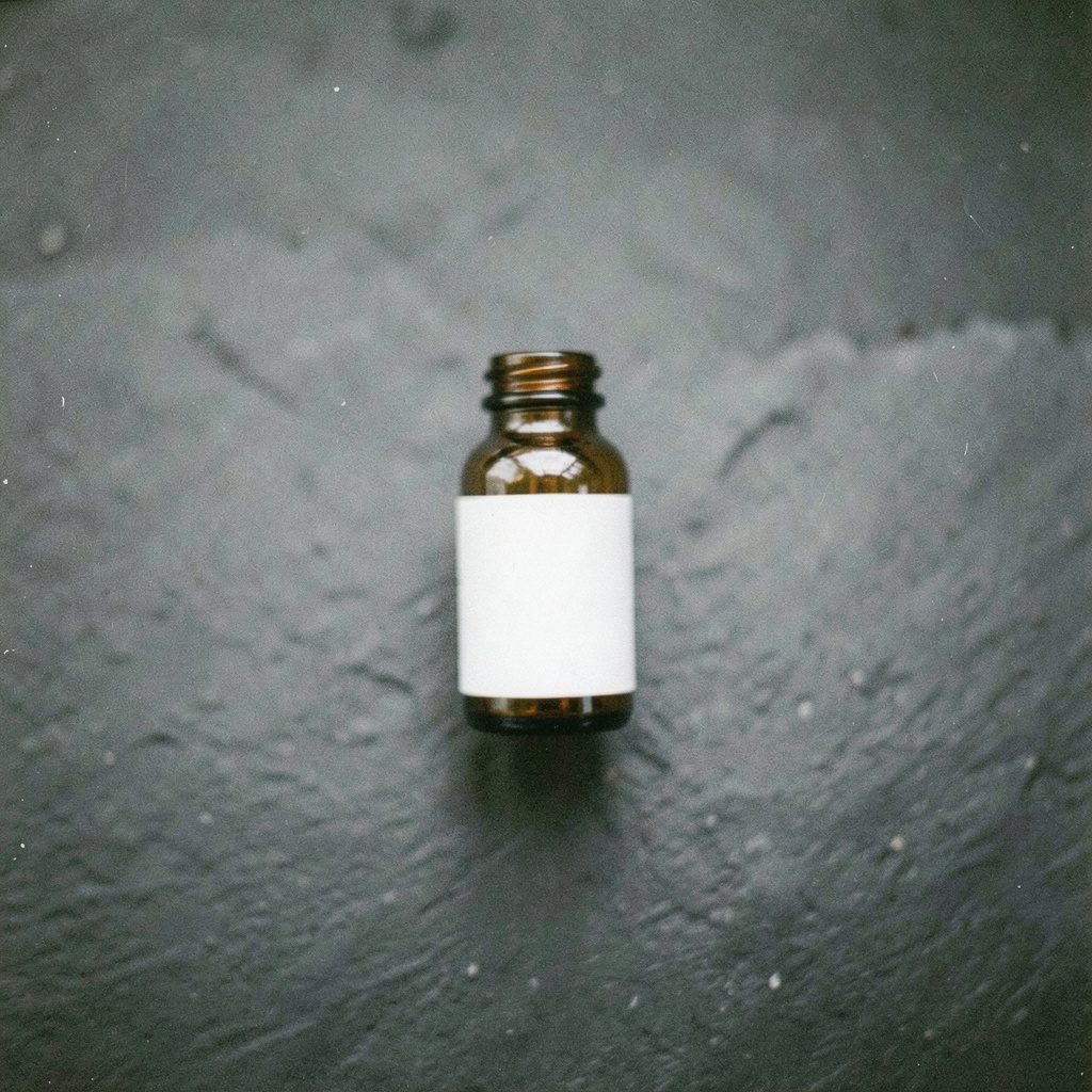 A grainy film photograph of a small amber glass vial with a white label, placed on a dark slate surface, moody and clinical.